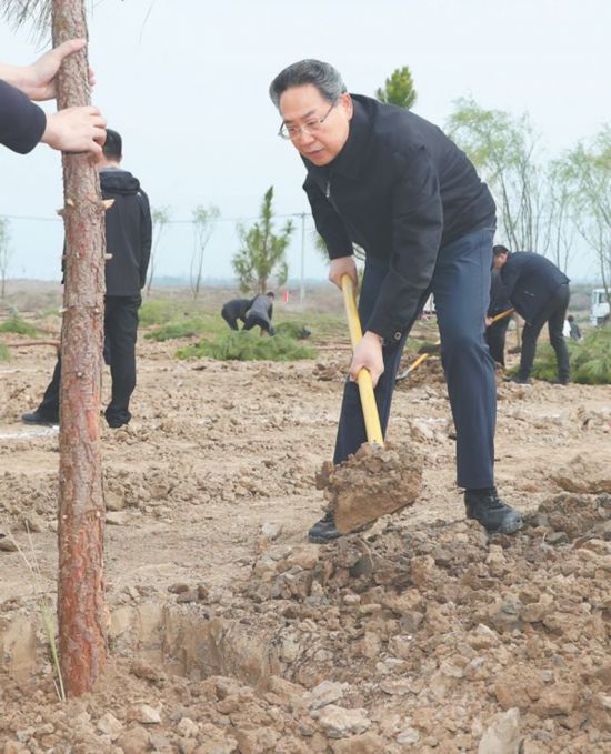 月 日,省委书记李锦斌在挥锹给树苗培土.记者徐国康摄