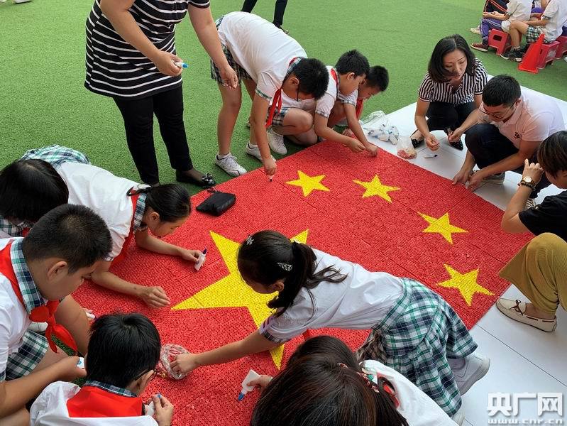 师生们用衍纸卷制作五星红旗(央广网记者苏平摄)